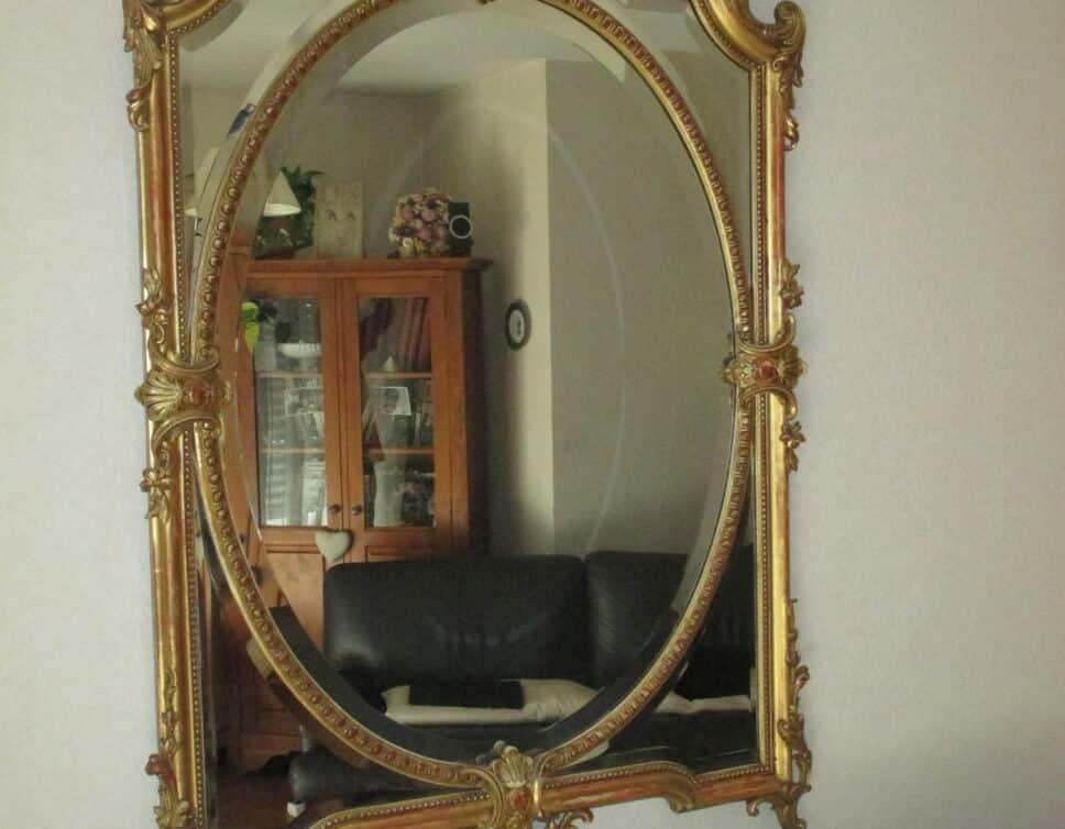 Miroir Ancien cadre stylisé doré.