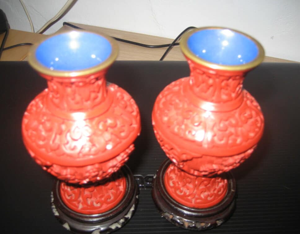 2 mini vases rouge sculptés posés sur socle en bois noir h 10,5 cms, diamètre de l’ouverture 4 cms